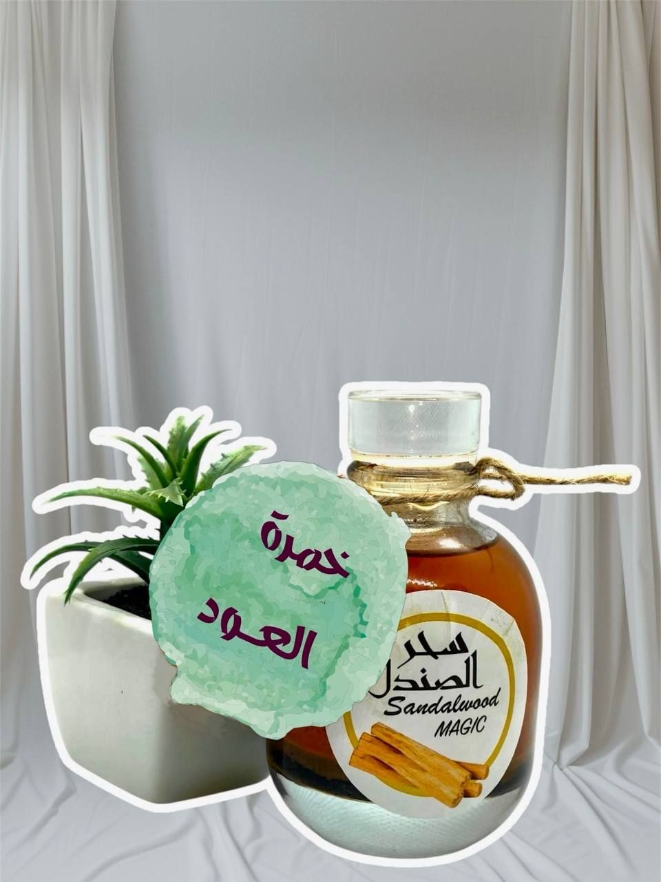 Decorative sandalwood bottle next to a potted plant against a neutral fabric backdrop.